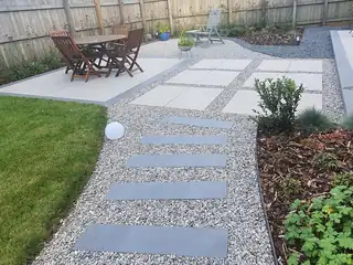 Paving slabs and gravel path leading to a dining set