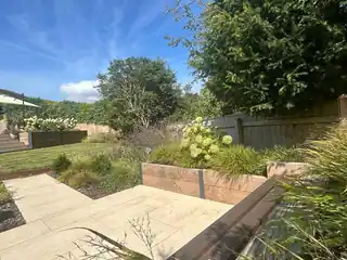 Sandstone paving and timber raised beds